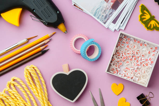 istock Crafting supplies arranged on a pink background, including glue gun, scissors, and decorative items for DIY projects 2171451421