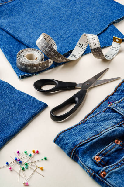 istock Sewing supplies and denim fabric arranged on a workspace for clothing alterations in a bright setting 2171451921