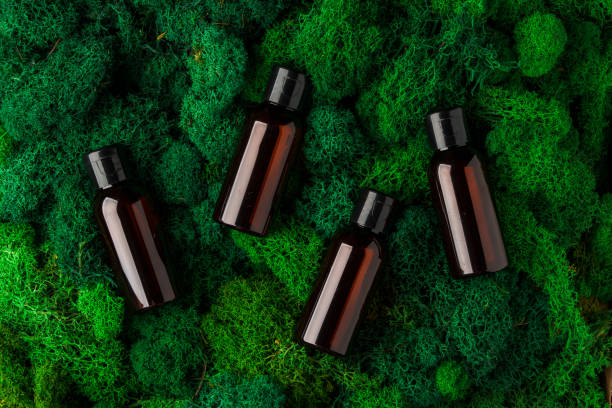 istock Four dark glass bottles arranged on vibrant green moss background 2171453550