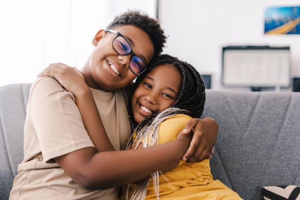 istock Two happy children embracing on sofa at home 2171457088