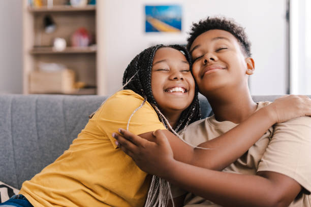 istock Two happy children hugging tightly on sofa 2171457089