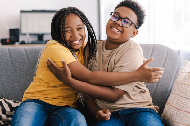 istock Two young siblings embracing lovingly on a sofa at home 2171457091