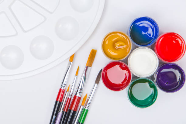 Paintbrushes of different sizes, pellets and gouache paints. Concept. View from above.