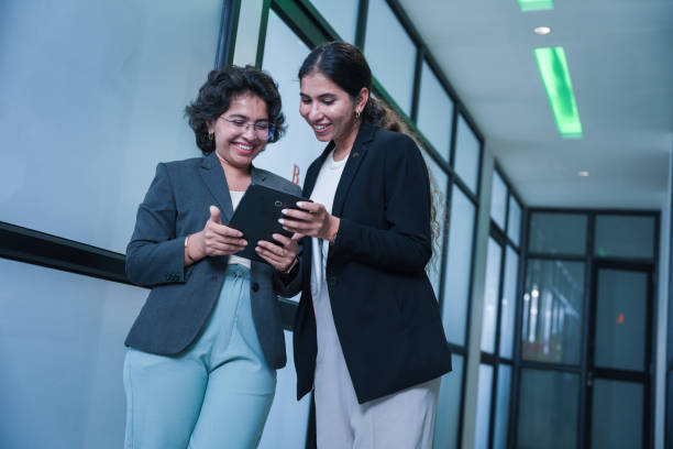 istock Two indian female entrepreneurs consulting on new project using digital tablet standing in office. workplace, business and corporate concept. 2171459623