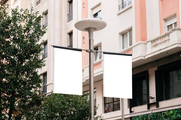 Blank posters on a street lamp in a city