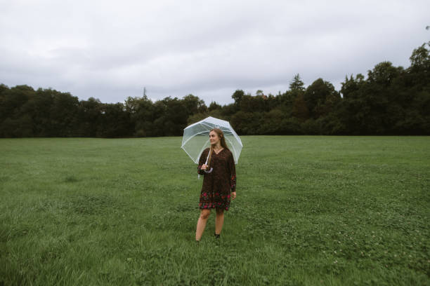 Woman with an umbrella on a green grass field