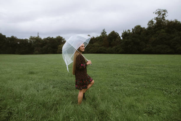 Woman with an umbrella on a green grass field