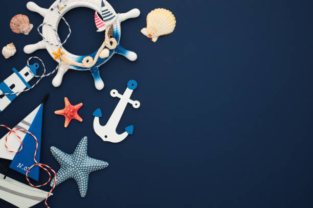 istock Maritime objects on a navy blue background. Flat lay nautical decor, sailboat, wheel, anchor, lighthouse, sea stars, seashells 2171467781