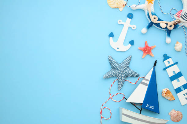 istock Nautical decor and marine elements on blue backdrop. Featuring a white anchor, sailboat, seashells, starfish, and decorative ropes. Perfect for sailing, sea, and maritime-themed designs 2171467879
