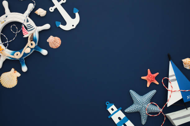 istock Nautical decor elements on navy background. Perfect for maritime themes, summer designs, and coastal interiors. Includes anchor, wheel, seashells, starfish, and sailboat. 2171467919