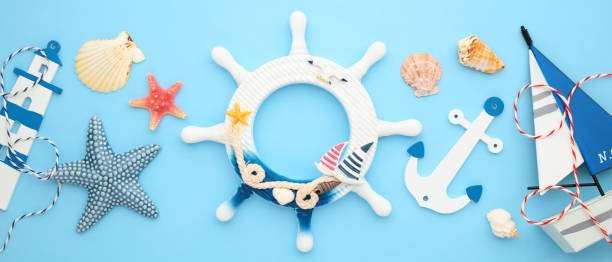 istock Nautical flat lay composition with maritime decor, wheel, starfish, seashells, anchor, lighthouse, boat on blue background 2171468030