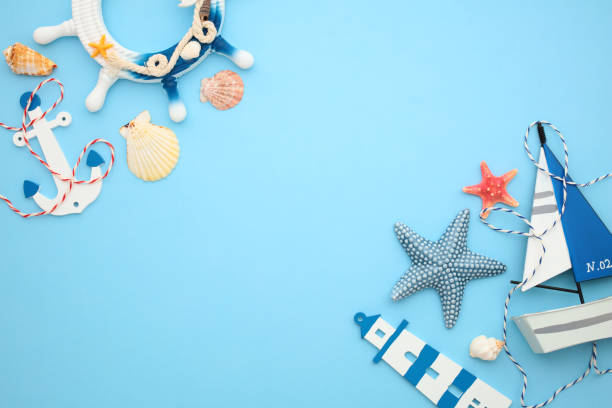 Nautical-themed decor with sailboat, wheel, starfish, and seashells on a blue background. Ideal for summer, travel, and coastal design content