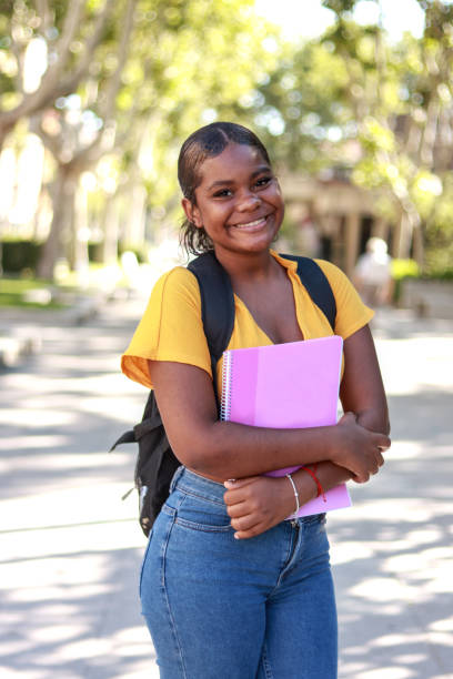 istock A happy black student holding a pink folder and wearing a backpack while smiling 2171470817