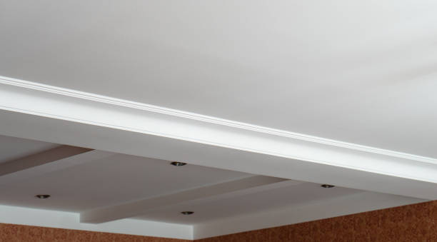 istock Suspended and grid ceiling with LED spots lamps and drywall construction in empty room in house interior. Stretch ceiling white and complex shape. 2171471768