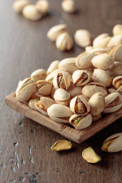 istock Salted pistachios on an old wooden table. 2171472956