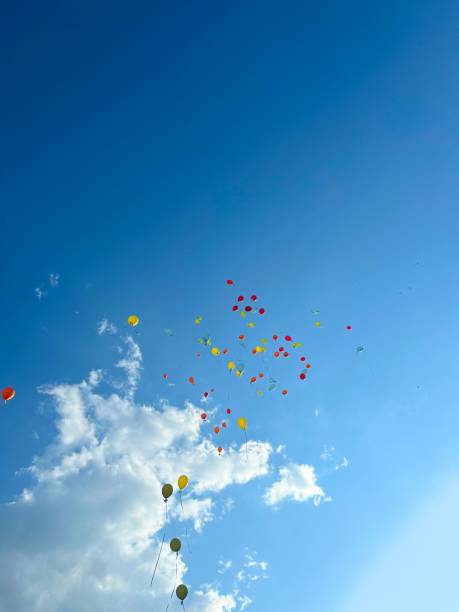 Five colorful air balloons over blue sky and white clouds.