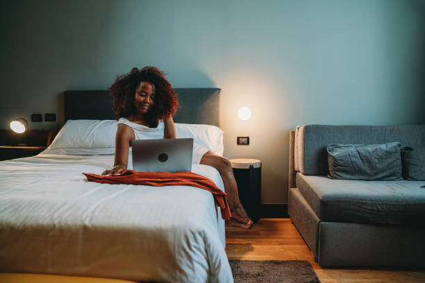 istock A businesswoman is using a laptop while she's lying down on the hotel bed 2171479771