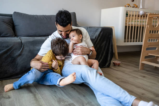 istock Young father playing with his two little kids at home 2171481165