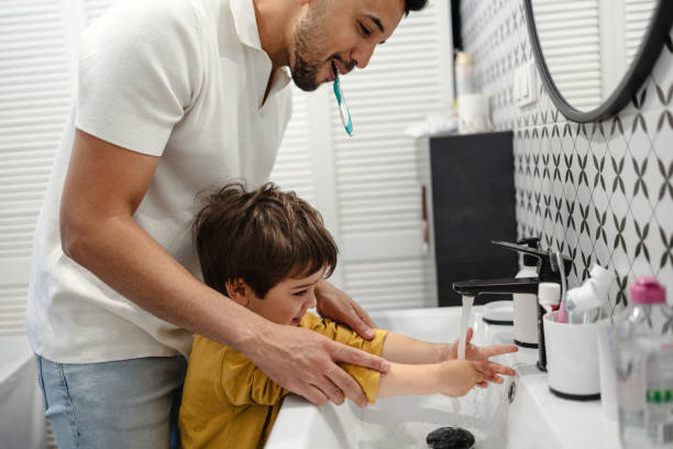 istock Father and son washing their hands in the bathroom 2171481166