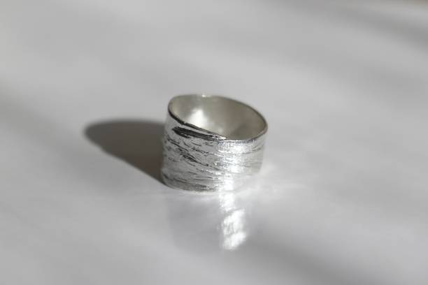 istock Wide textured silver ring with leaves pattern on a white background. Handmade jewelry. 2171486530
