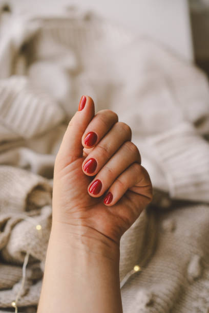 istock Cozy winter setting with a hand displaying red nail polish 2171487328