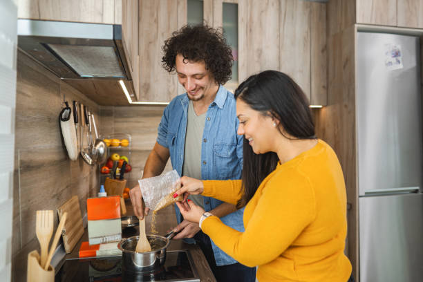 istock Joyful cooking together in a modern kitchen while preparing a delicious meal during a sunny afternoon 2171487781
