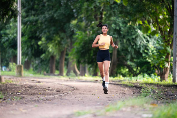 istock Young Woman Running in a Scenic Park 2171495356