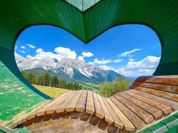 istock Scenic view of a mountain range framed by a heart-shaped wooden structure under a clear blue sky 2171495720