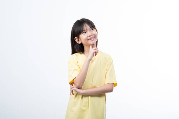 Young girl standing in front of blank wall with expressive face