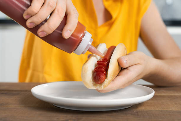 istock Person Adding Ketchup to Hot Dog, lunch, breakfast 2171500843