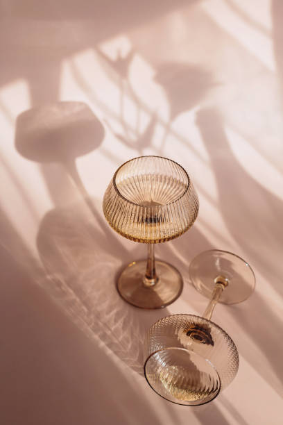istock Two glasses with white wine placed on light beige background with shadows 2171502808