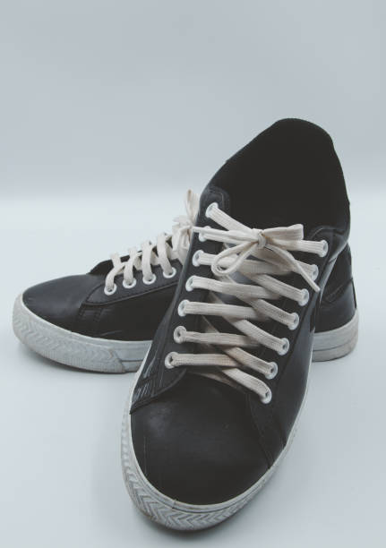 istock shoe sneaker on white background, close up of sneaker on white background, old black generic sneakers on white background. 2171503263