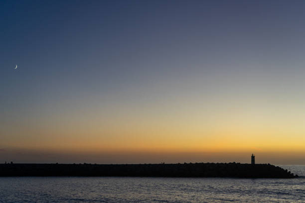 Sunset hues linger as the moon rises.