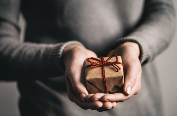 istock Hands holding little gift with red bow. Close up. 2171515841