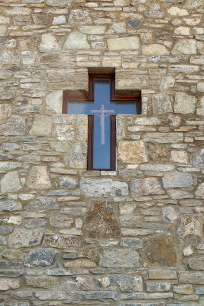 Window in the form of a cross. On the fireplace wall.