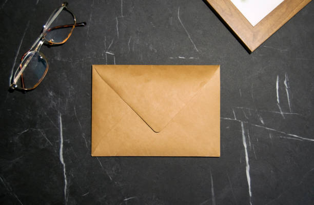 istock Blank kraft paper envelope on black marble background.Top view. 2171516352