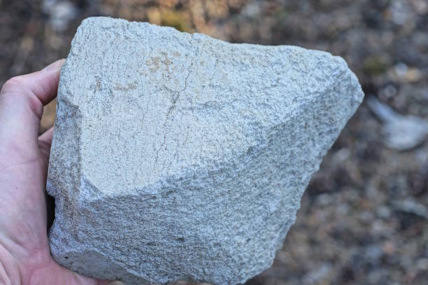 istock a man hand holds a large white piece of stone brick 2171520076