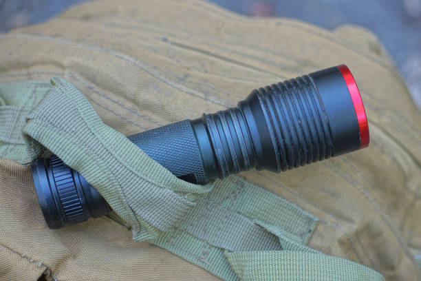 istock one black metal flashlight lies strapped to a brown army backpack 2171520410
