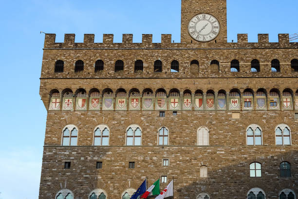 Florence, Italy - April 13, 2023: The historic Palazzo Vecchio is still Florence's town hall, but it also serves as a museum and is seen here in the colours of the evening light.