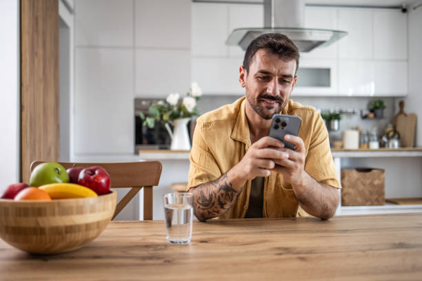 istock An adult man uses his smartphone while sitting at a table 2171520825