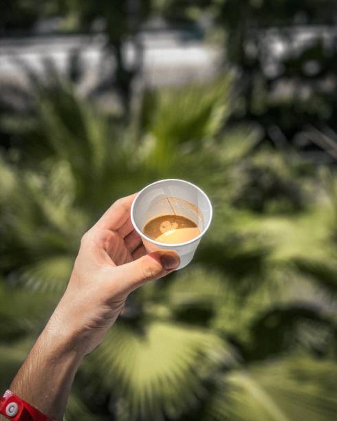 Holding A Cup Of Coffee, Overhead View, Close- Up, With Trees In The Background