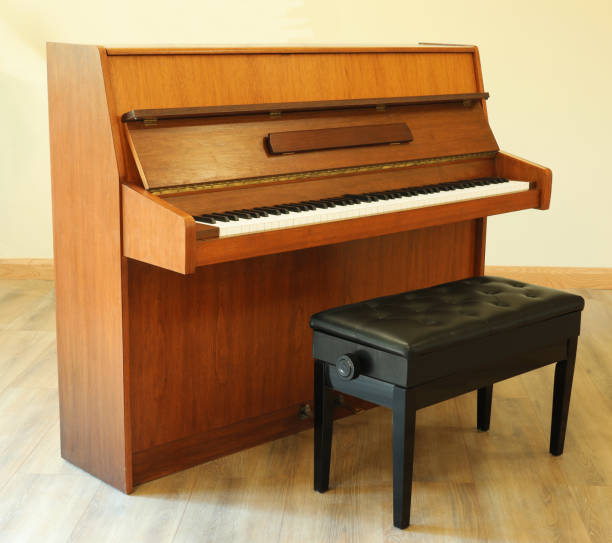 Upright piano with seat. Musical instruments concept
