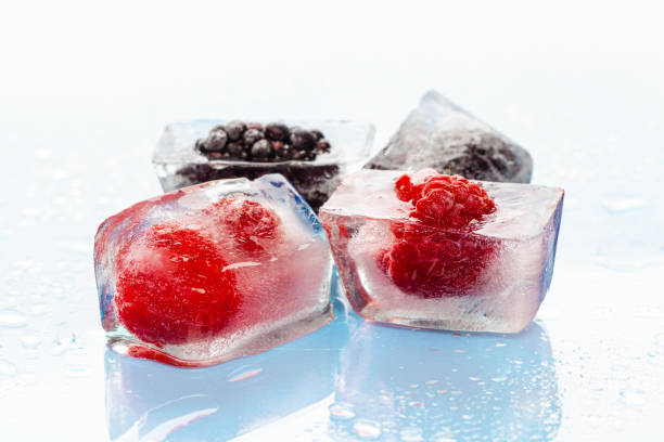 istock Ice cubes with frozen berries inside close up 2171524504