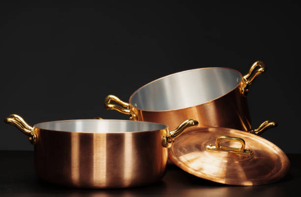 Set of copper cookware over dark background