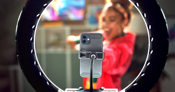 istock Happy woman, influencer and phone with ring light for video recording, online tutorial or communication at home. Young, female person or vlogger with mobile smartphone for dance or content creation 2171531926