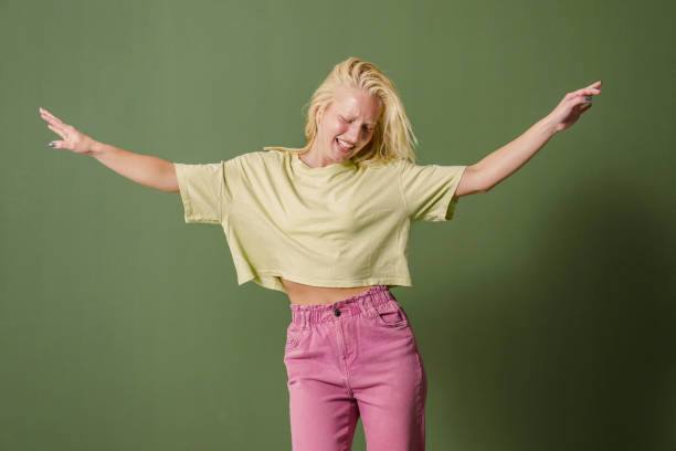 istock Joyful Young Woman Dancing Solo on Green Backdrop 2171532638
