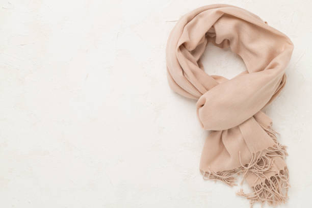 Stylish scarf on concrete background, top view