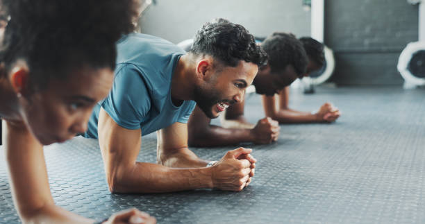 istock Exercise, plank and power with group friends on gym floor together for training or workout. Fitness, strength and sports with athlete people in health club for intense challenge or performance 2171536371