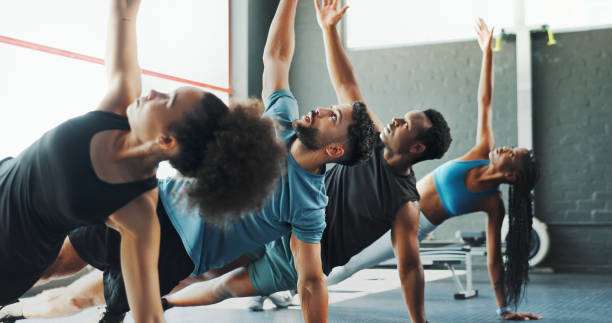 istock Group, stretching and challenge with fitness, training and endurance for core, workout and practice. Diversity, healthy friends and men with women, exercise and energy in gym, support and balance 2171536374