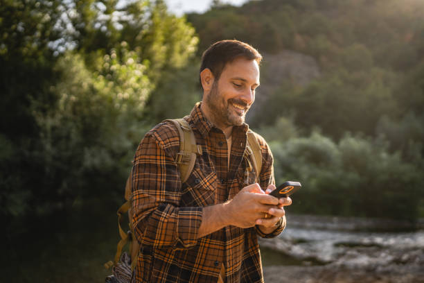 Adult man explore nature while check mobile phone in a serene setting
